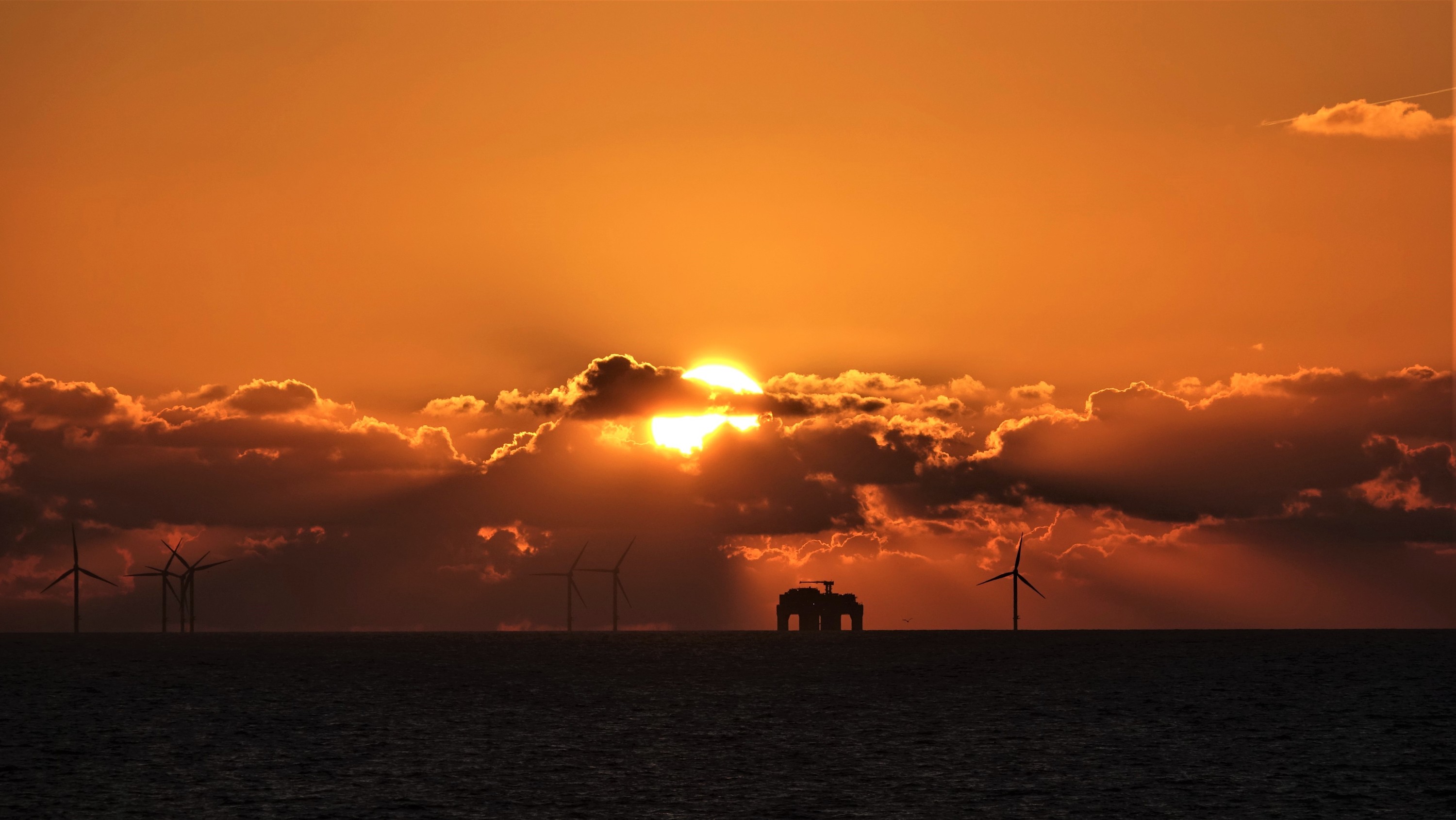 Sonnenuntergang mit Bohrinsel an der ostfriesischen Küste